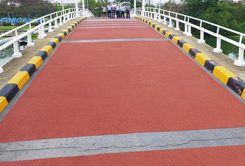 Road coated with heat-blocking slip-resistant surfacing material