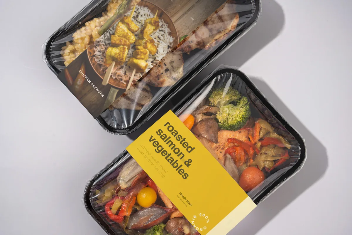 Two film-sealed ready-meal trays with a menu label